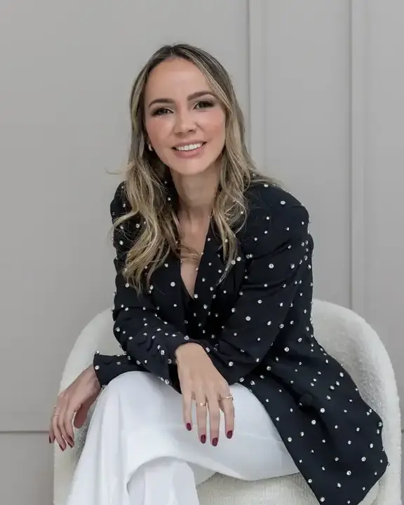 Dra. Mirele Fadel sentada, de blazer de bolinhas